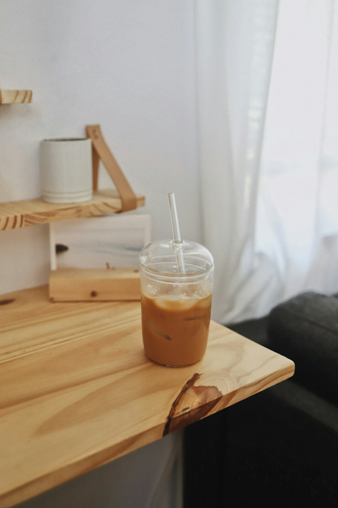 Open notebook with handwritten notes and a cup of coffee on a wooden desk